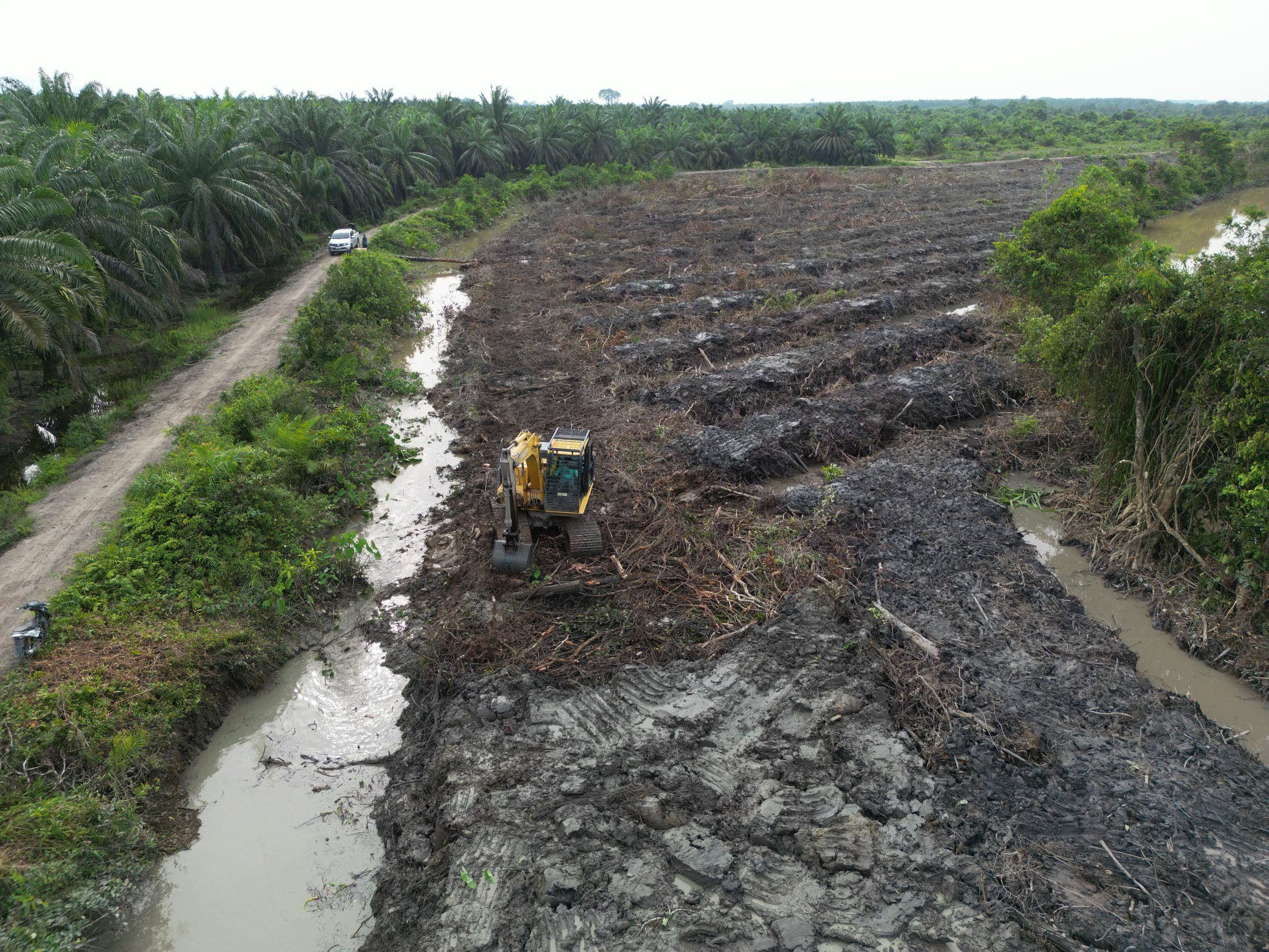Excavator Komatsu menggali parit di lahan yang baru dibuka di Mersam, Batang Hari